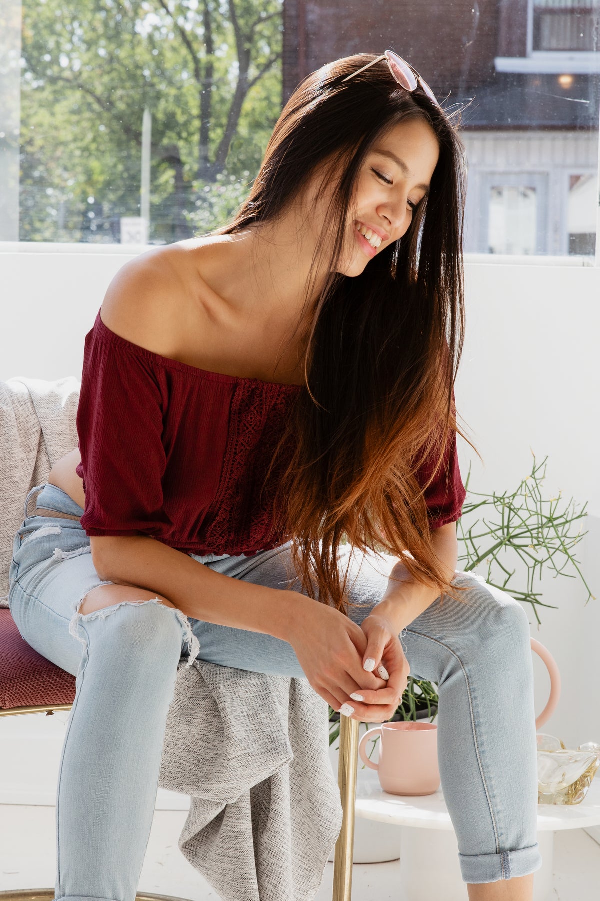 Woman smiles sitting in sunny window